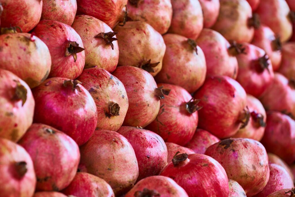Close-up view of vibrant and ripe pomegranates displaying their organic texture and rich red colors.