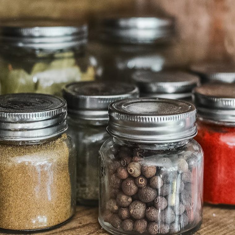 pexels-photo-531446-531446 Close-up of assorted spice jars with various herbs on a kitchen shelf, showcasing colorful culinary ingredients.